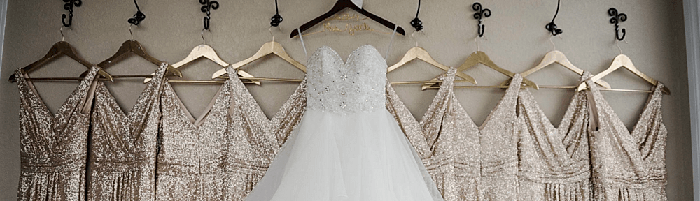 Wedding dress and gold bridesmaid dresses hanging in bridal suite at Kendall Point