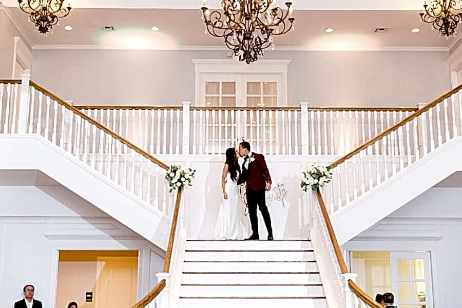 Bride and Groom kiss on the grand staircase at Kendall Point