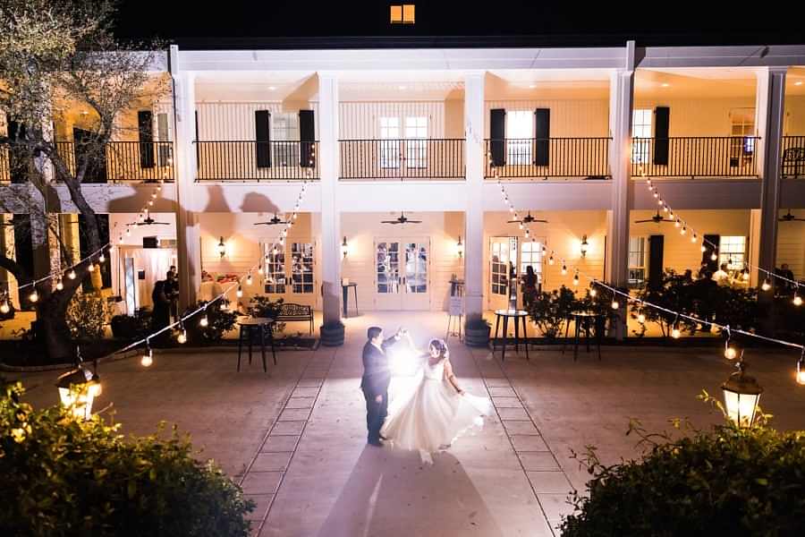 Bride and groom dance on lit Kendall Point veranda