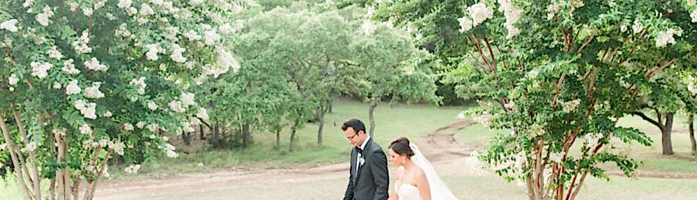 A bride and groom walk along the Kendall Point grounds.