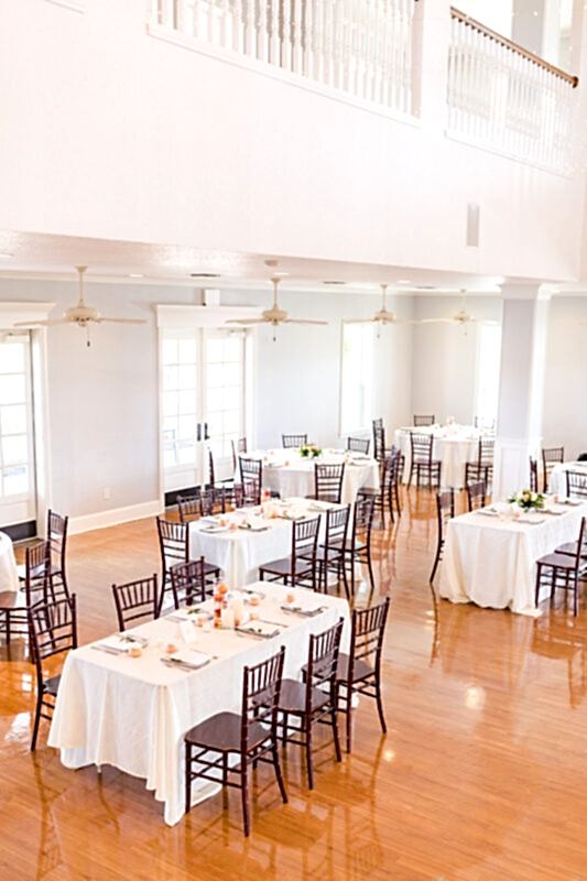 The ballroom is set for dinner with tables along the sides and the dance floor in the middle. Extra spacing added between tables to allow for social distancing.