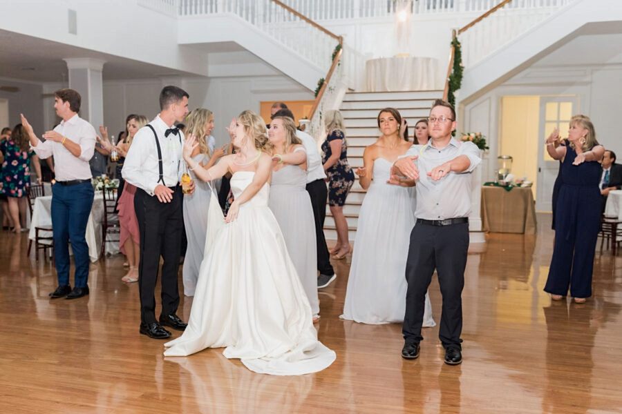 The bride Heather leads a line dance with her bridesmaids and more guests.