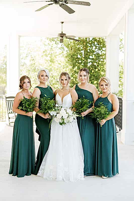 A bride and her bridesmaids in dark green dresses for a stunning fall wedding.