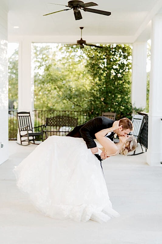 Bride and groom kiss on Kendall Point veranda