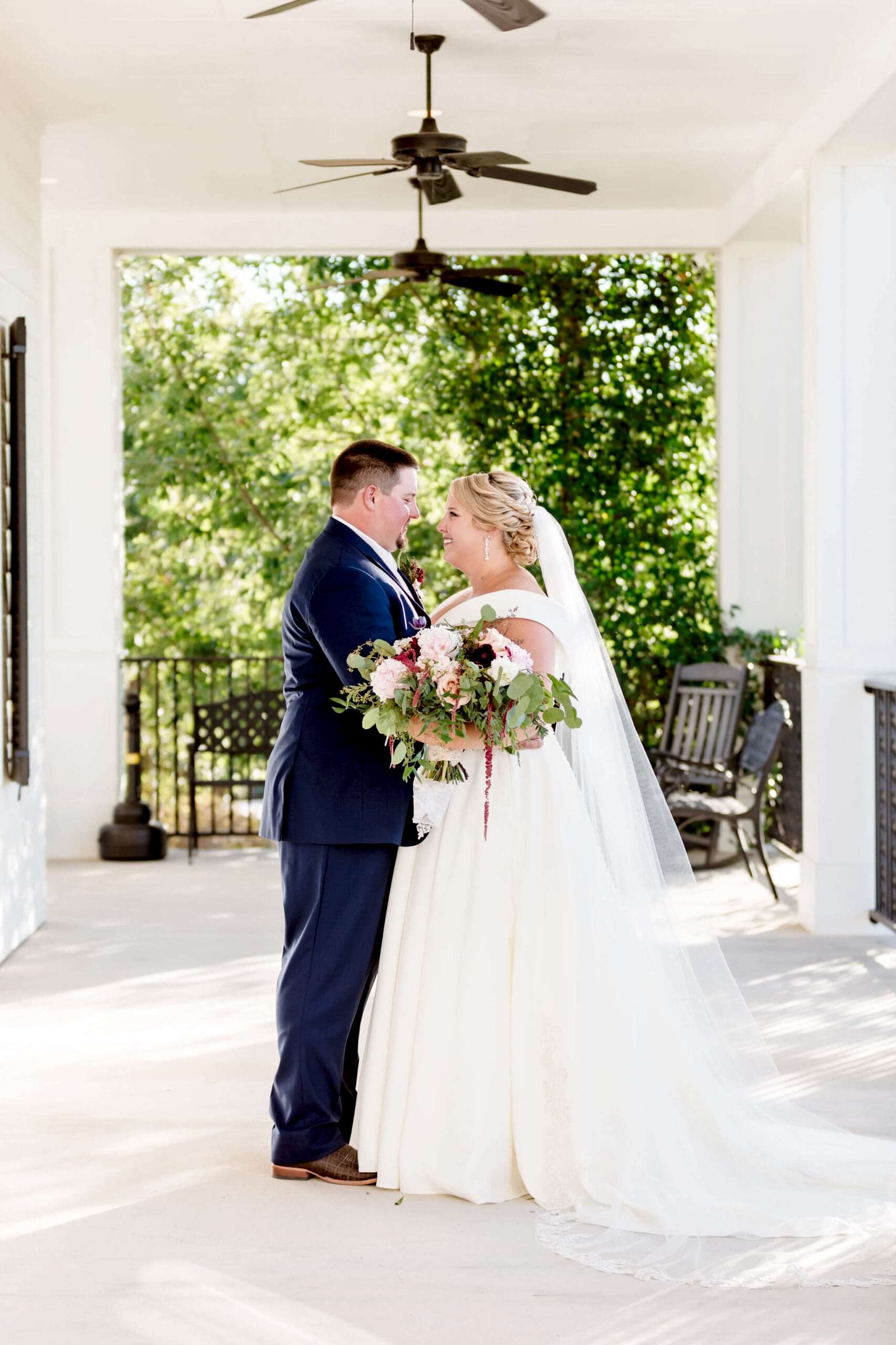 Bride and groom share a moment on the wrap-around porch at Kendall Point