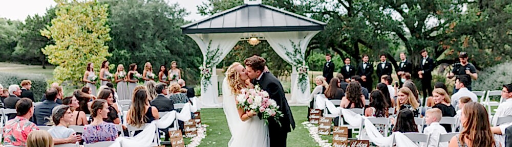 Bride and groom kiss in aisle during their Kendall Point wedding ceremony.