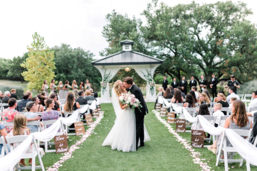 Bride and groom kiss in aisle during their Kendall Point wedding ceremony.