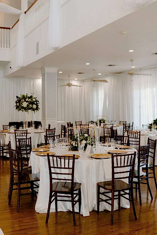Tables set up for an elegant white wedding reception at Kendall Point.
