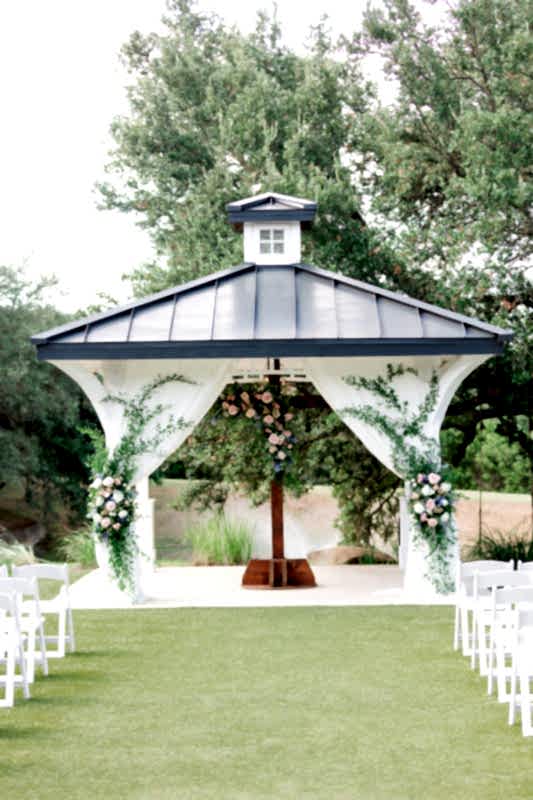 Cedar cross and Kendall Point gazebo adorned with pink and blue flowers