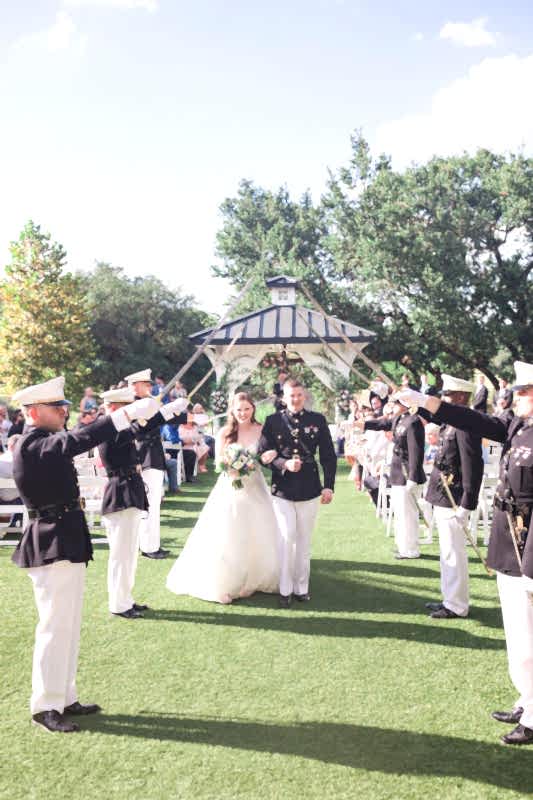Bride and groom walk beneath saber arch