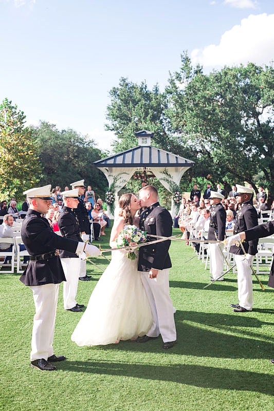 Bride and groom kiss after passing through saber arch