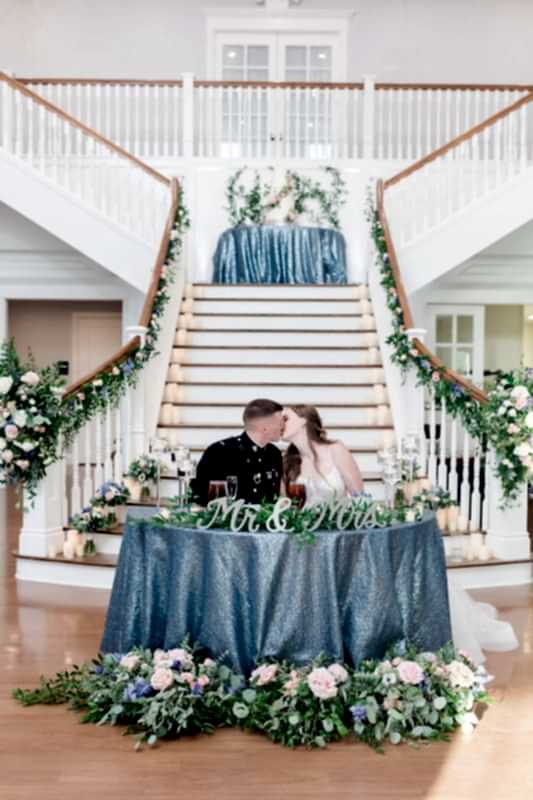 The couple kiss at the sweetheart's table.