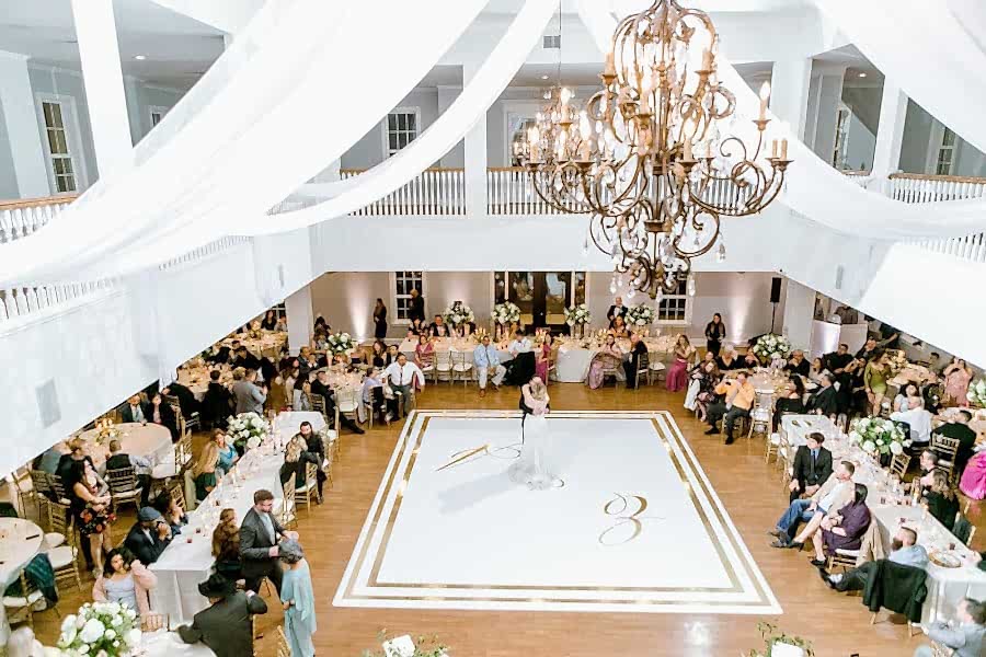 Bride and groom of their first dance surrounded by family in Kendall Point's ballroom.