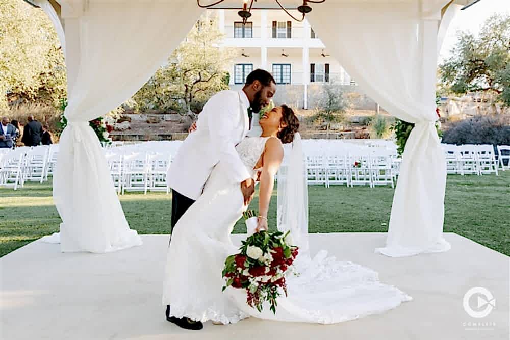 groom dipping bride under gazebo at Kendall Point Texas wedding venue