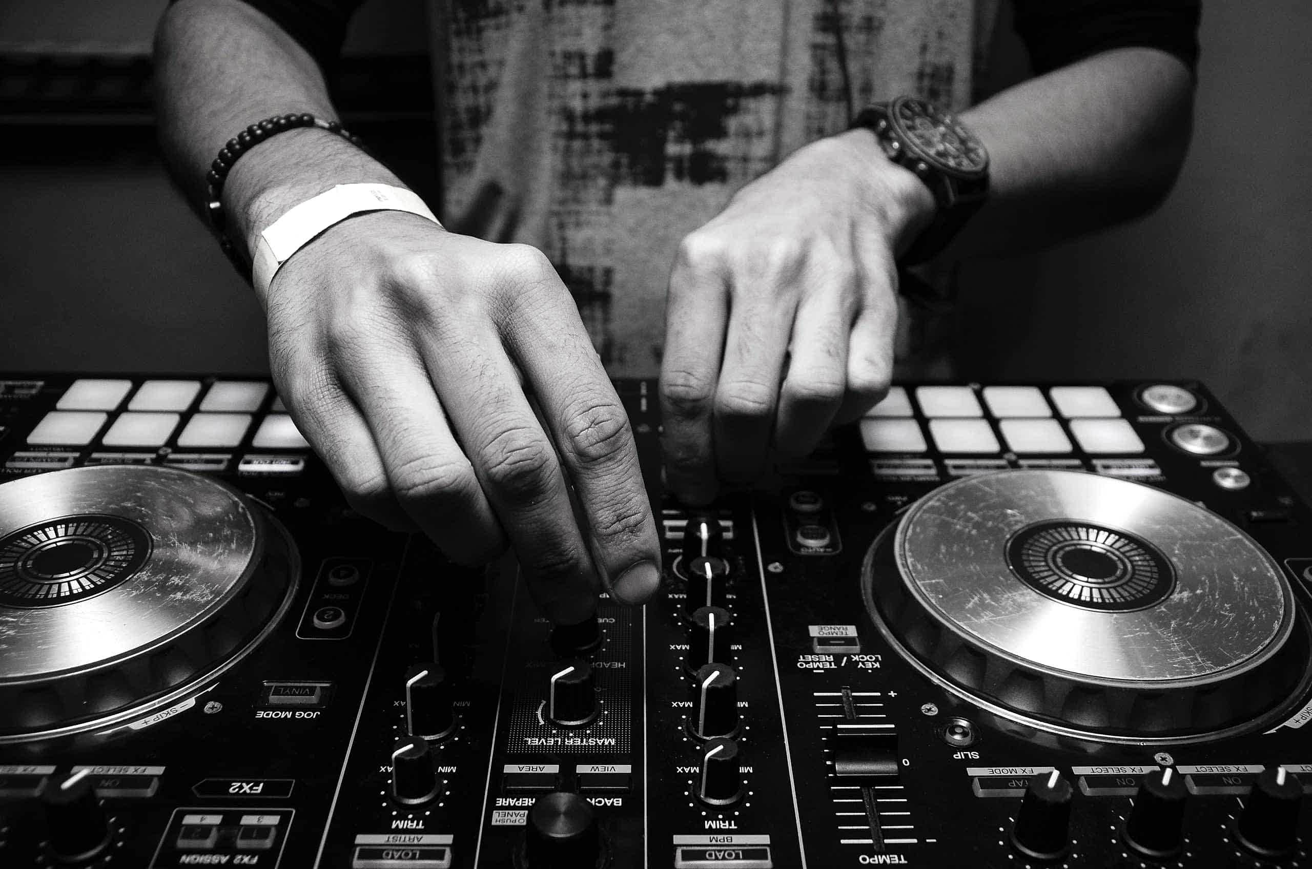 closeup of dj's hands at sound board