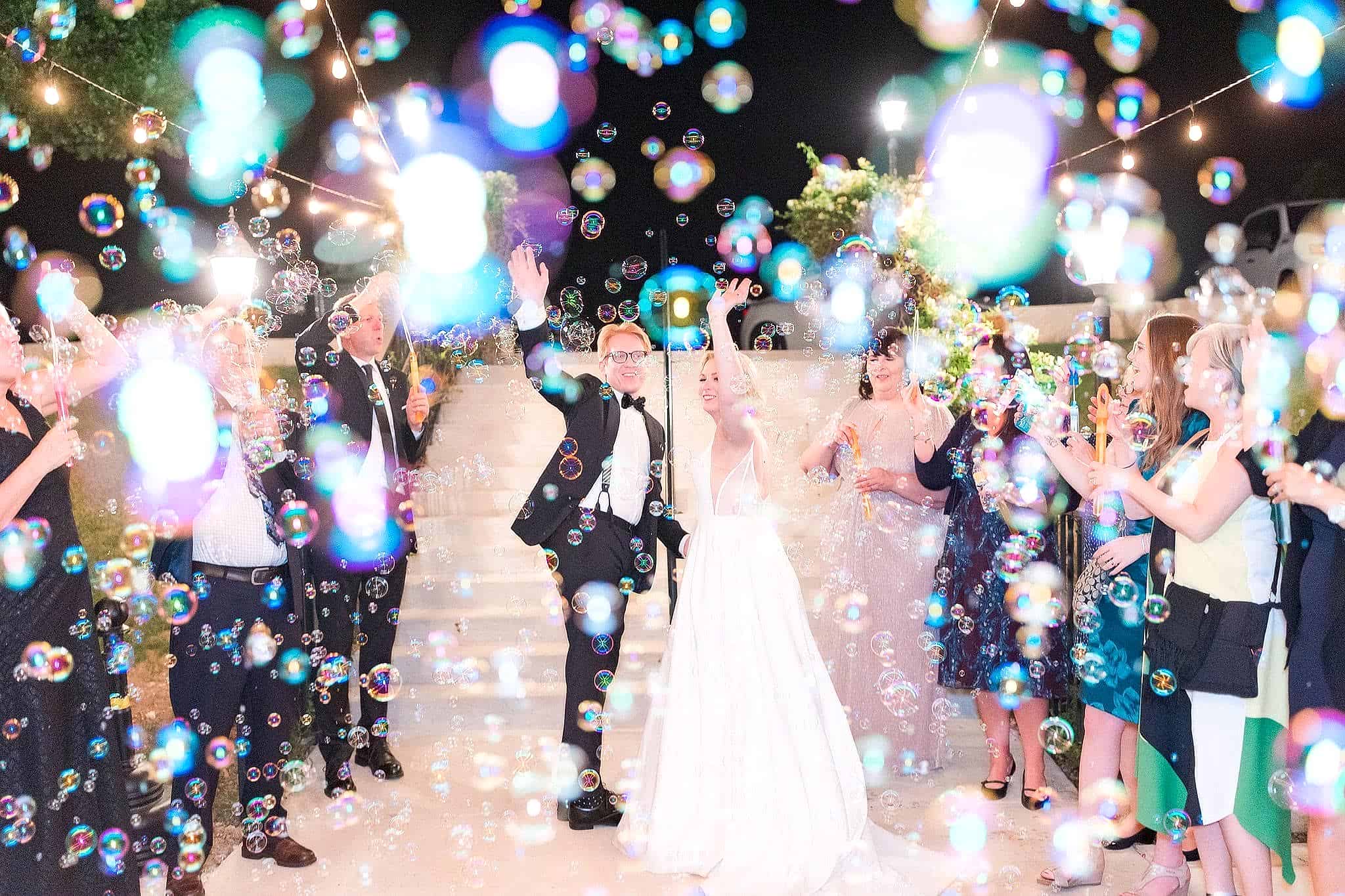 Bride and groom make grand exit under string lights.