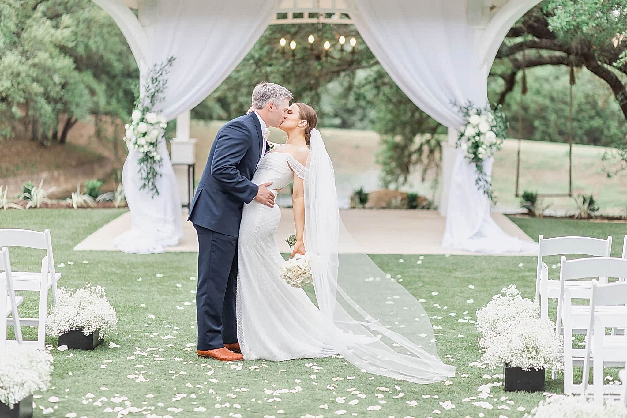 Bride and groom kiss after their outdoor ceremony under the gazebo at Kendall Point.