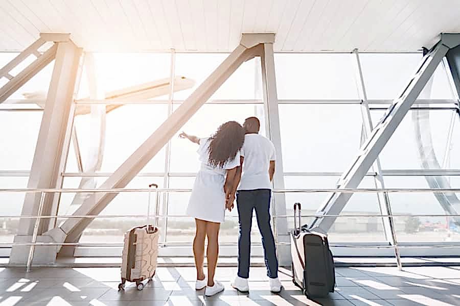 Newly married couple at the airport ready to leave for their honeymoon.