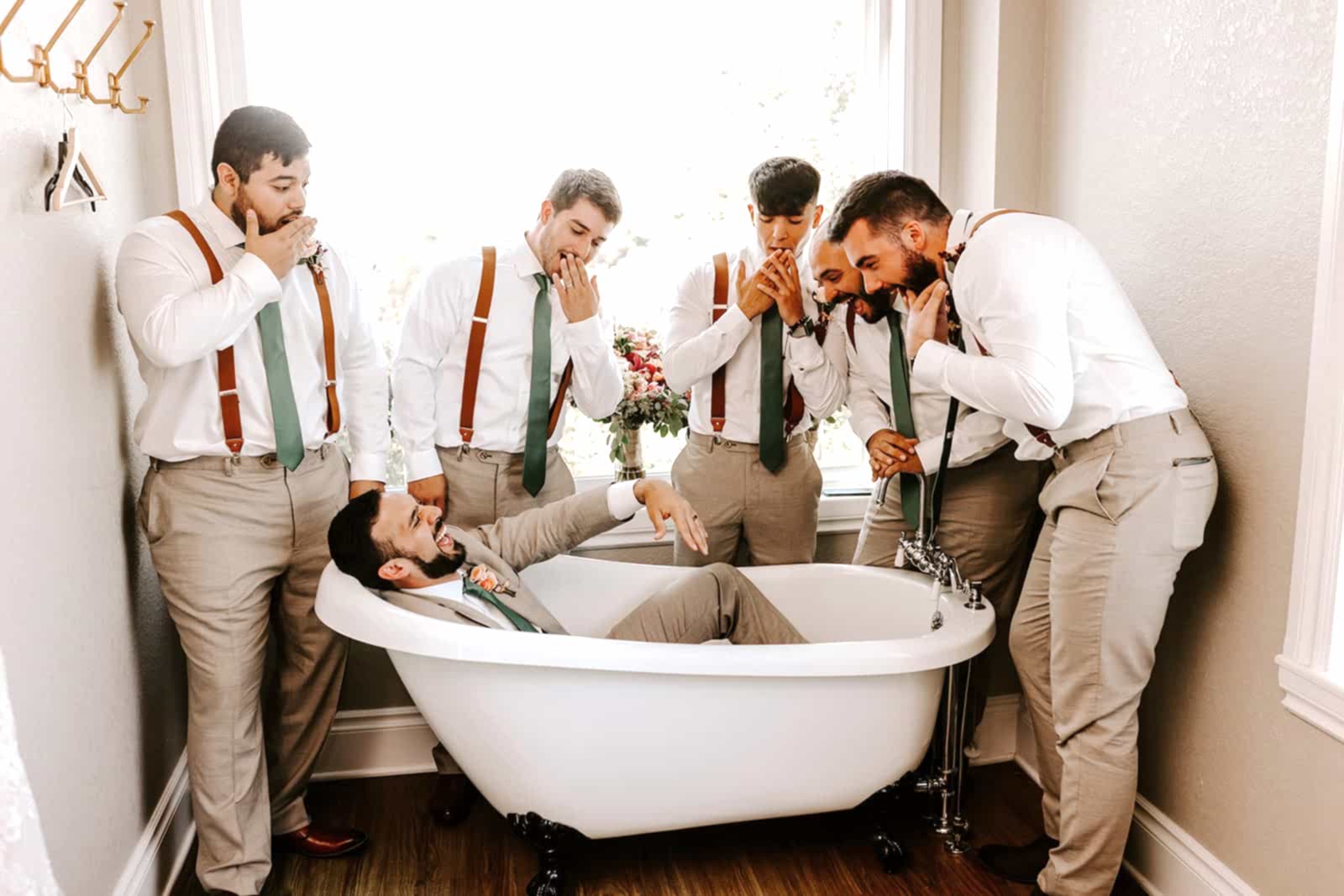 groom and groomsmen in khaki pants with rust suspenders