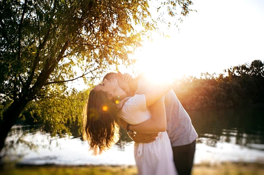 Engaged couple embrace during sunset for their engagement pictures.