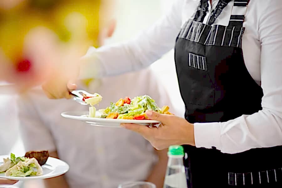 Waiter carrying plate of food at a wedding