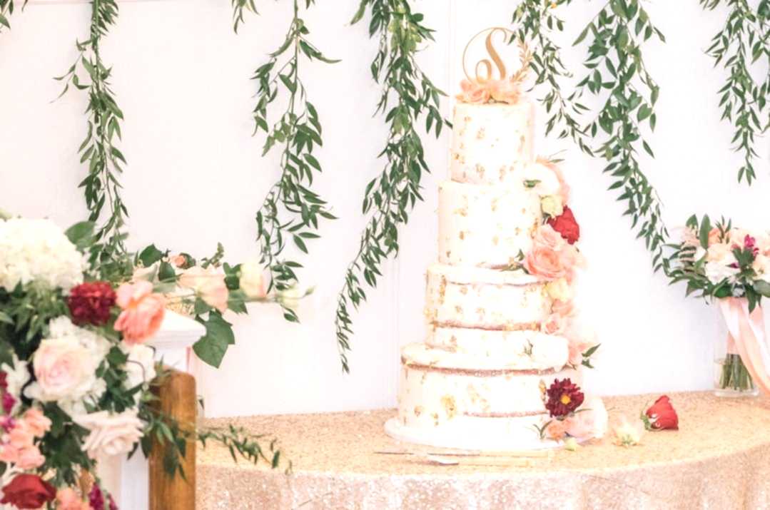 naked wedding cake with cake topper featuring couples' initial