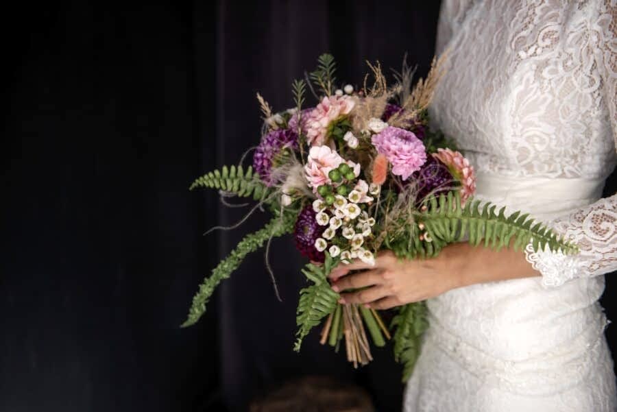 bride holding hand tied wedding bouquet