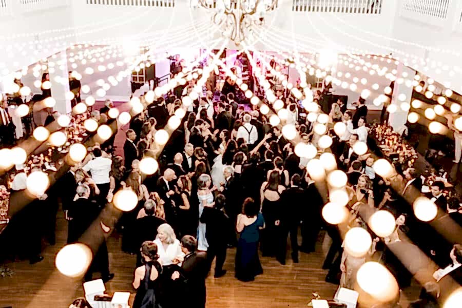 Wedding guests dance at Kendall Point wedding under string lights